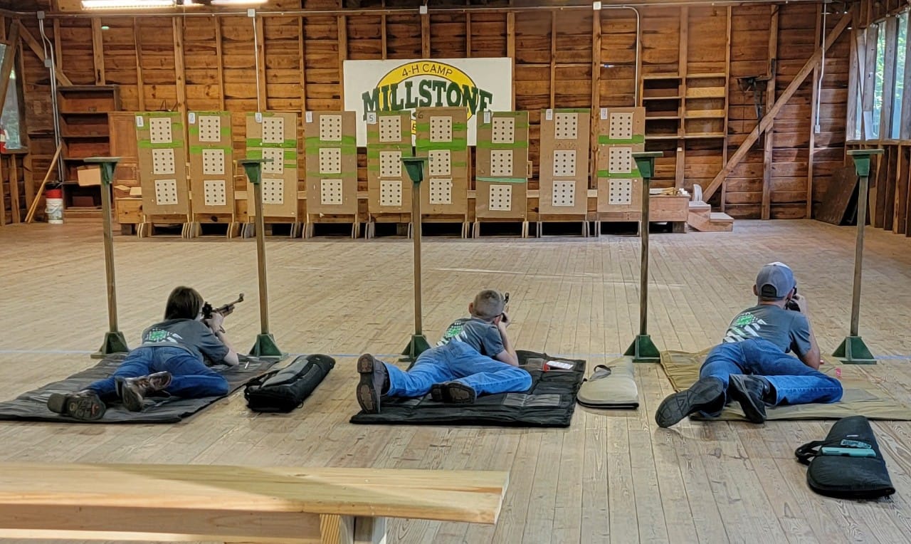 3 campers at Millstone camp lay prone for target practice.
